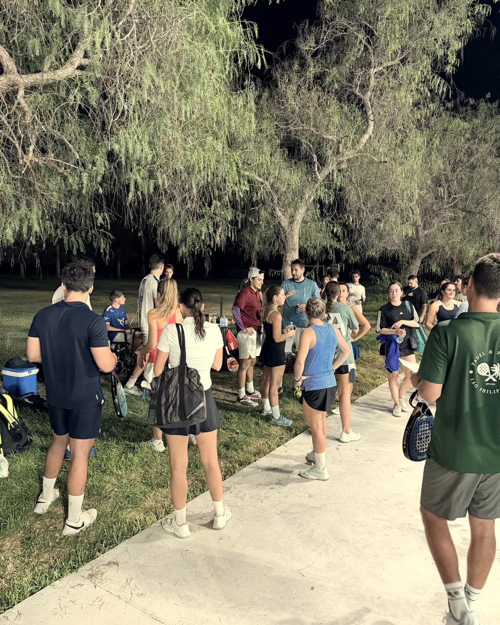 Players at night under the trees, in the club’s social area